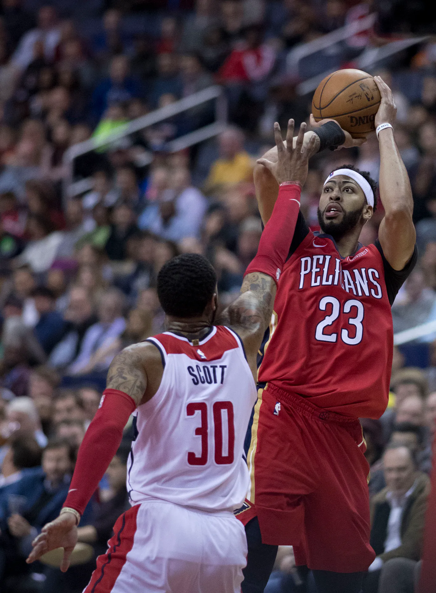 效力鵜鶘時期的 Anthony Davis 身穿紅色 23 號球衣面對巫師 30 號球員防守跳投出手（攝影 Keith Allison，CC BY-SA 2.0，Wikimedia Commons）