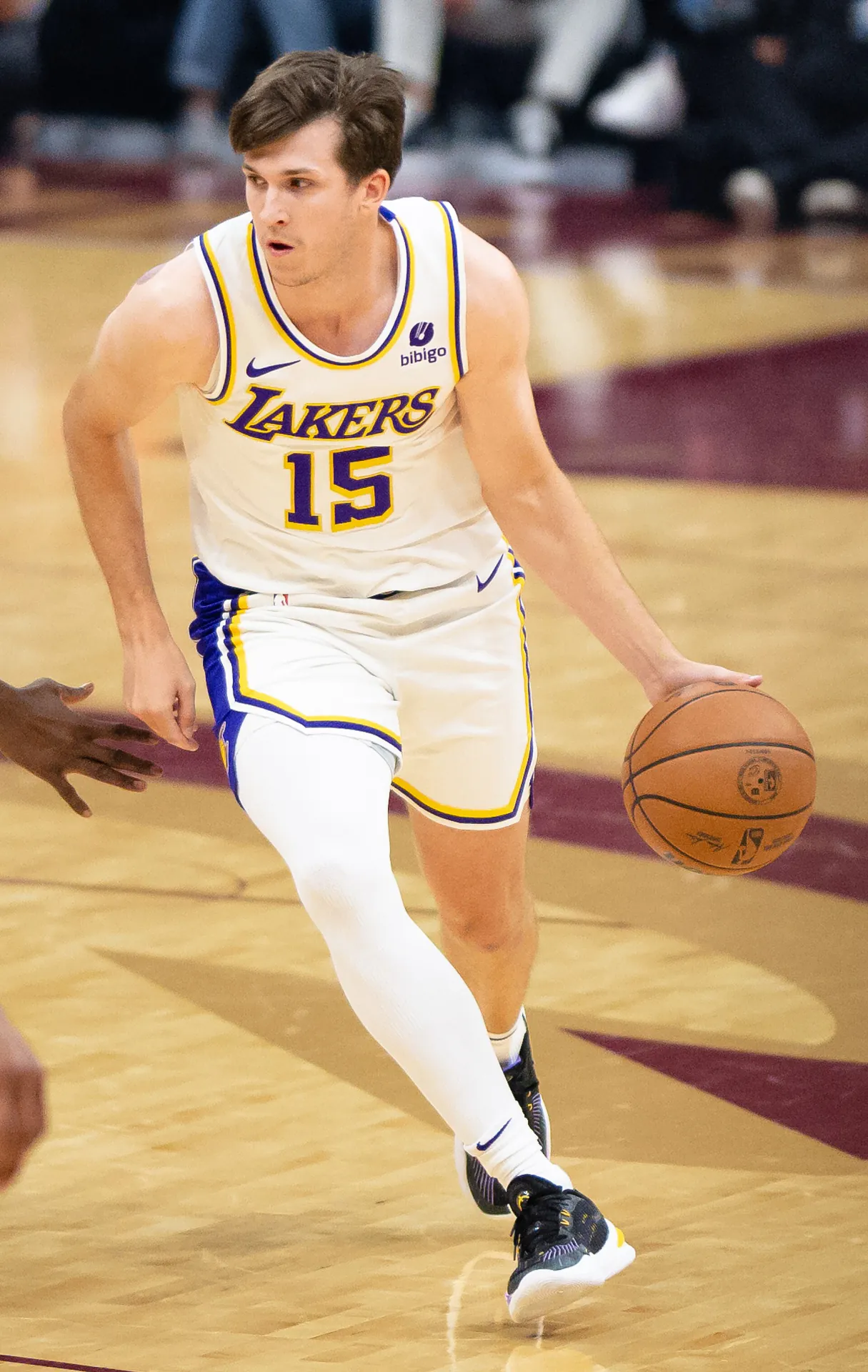 Austin Reaves 身穿洛杉磯湖人白色 15 號球衣，於 2023 年 11 月的 NBA 比賽中運球推進（攝影 Erik Drost，授權 CC BY 2.0，來源 Wikimedia Commons）