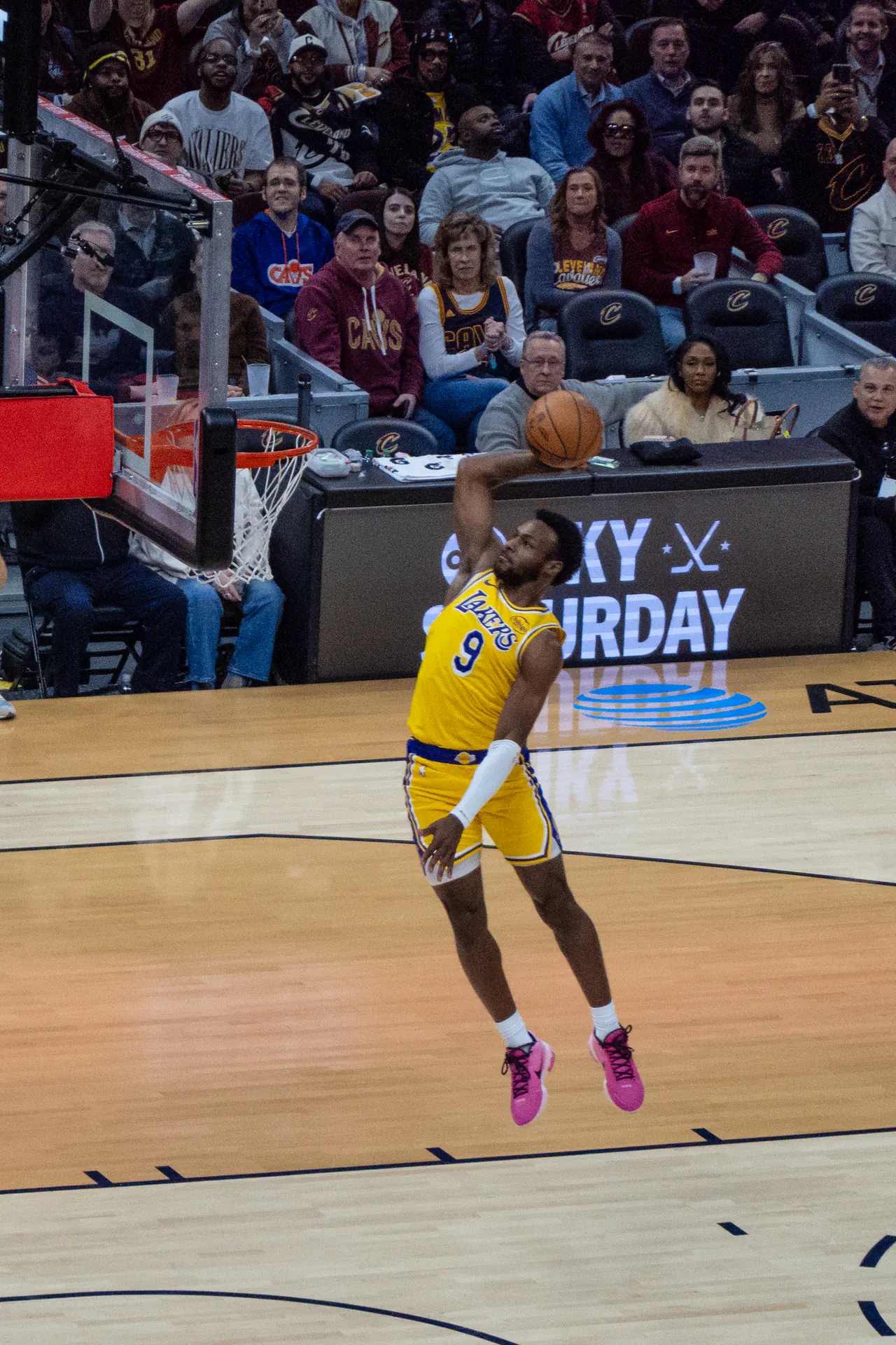 身穿湖人金色 9 號球衣的 Bronny James 在場上單手持球騰空準備灌籃