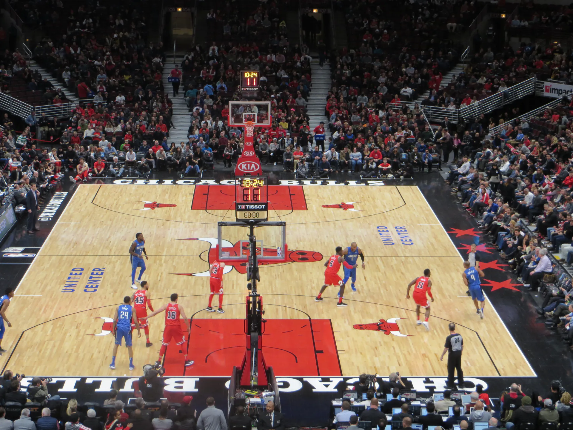 從 United Center 看台俯瞰公牛紅色球衣與魔術藍色球衣球員在場上攻防