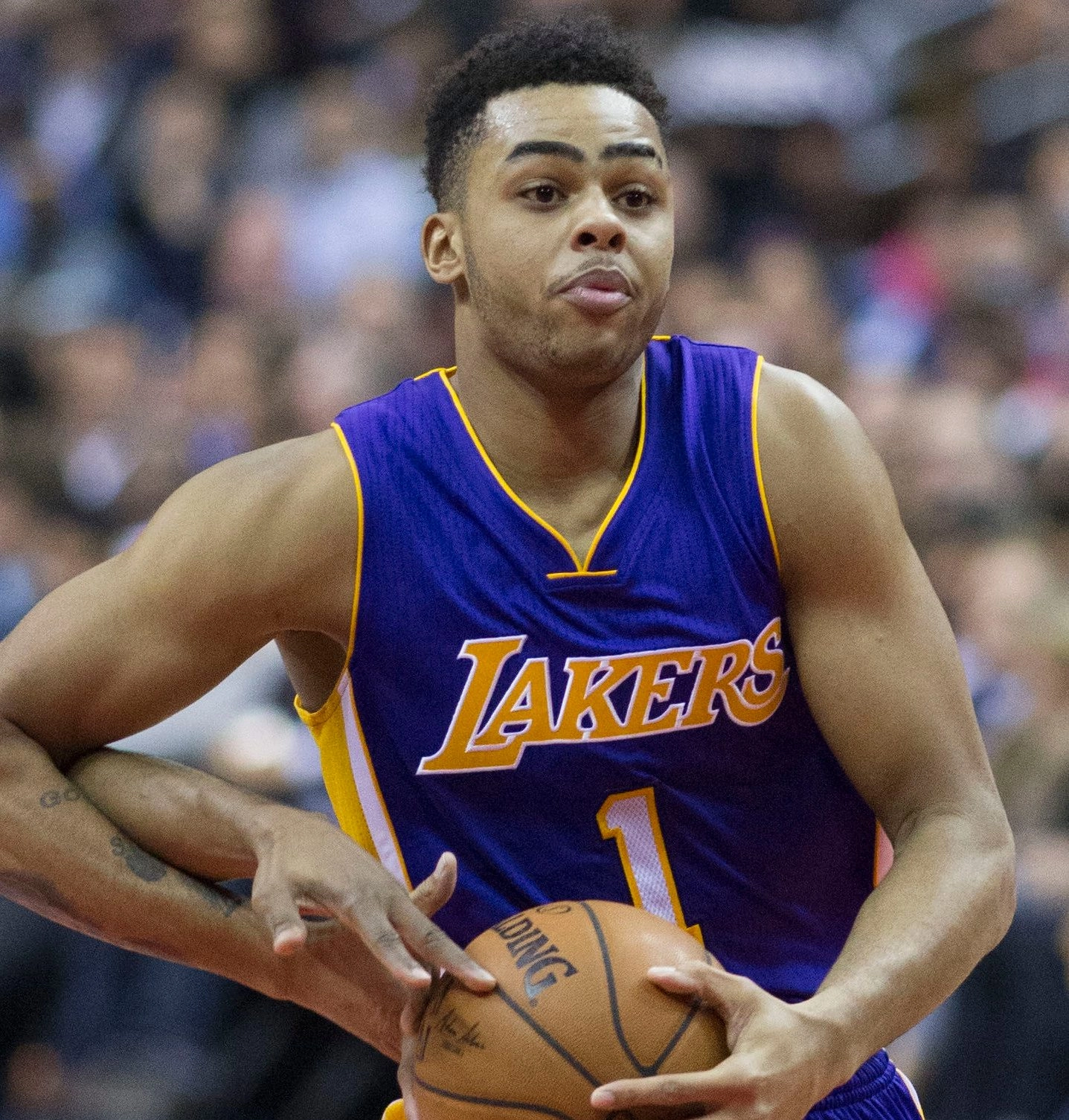 D'Angelo Russell 身穿湖人紫色 1 號客場球衣於比賽中收球準備進攻。攝影：Keith Allison，授權 CC BY-SA 2.0，來源 Wikimedia Commons。