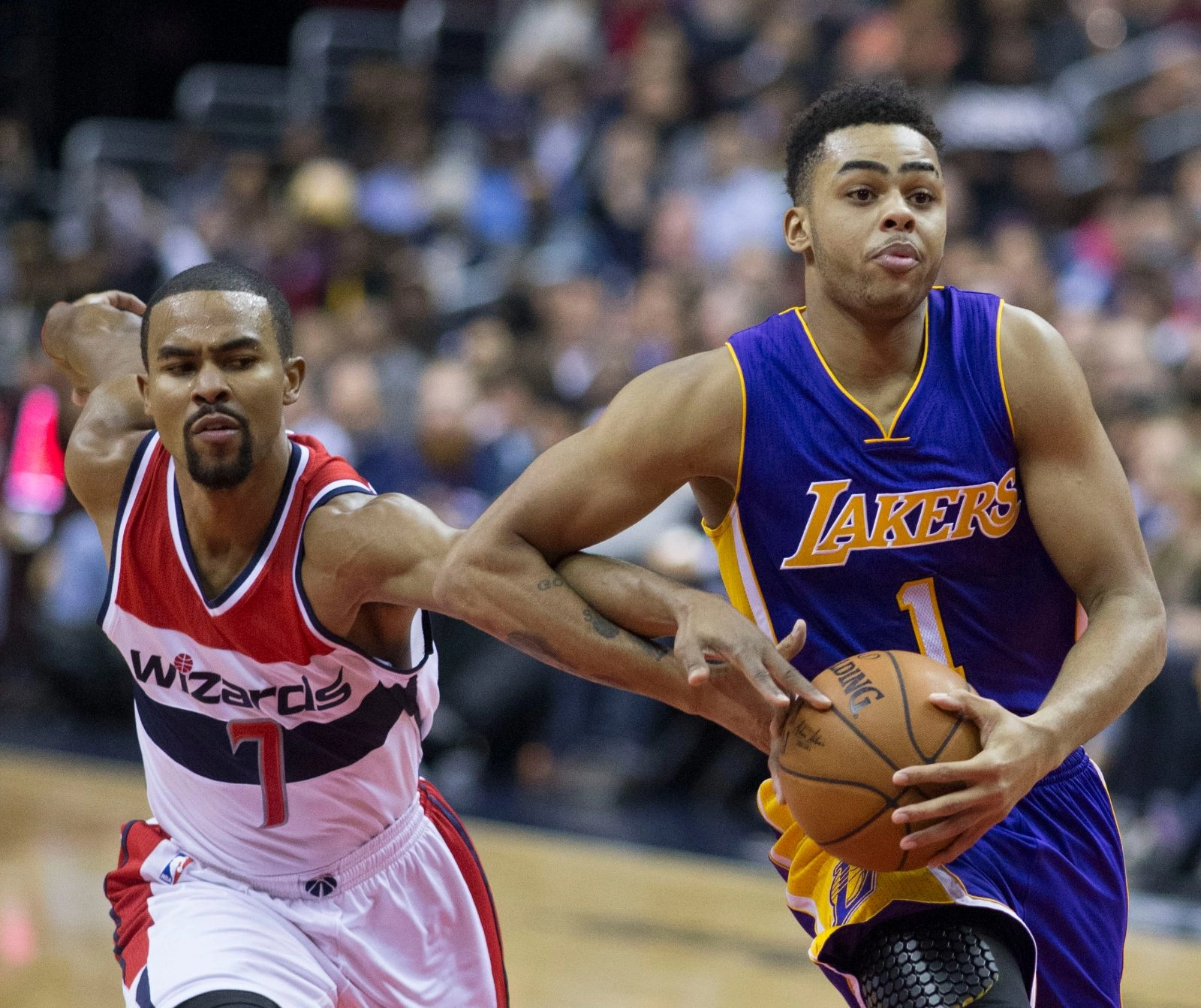 D'Angelo Russell 身穿湖人紫色 1 號球衣於比賽中持球切入，由華盛頓巫師球員防守。攝影：Keith Allison，授權 CC BY-SA 2.0，來源 Wikimedia Commons。