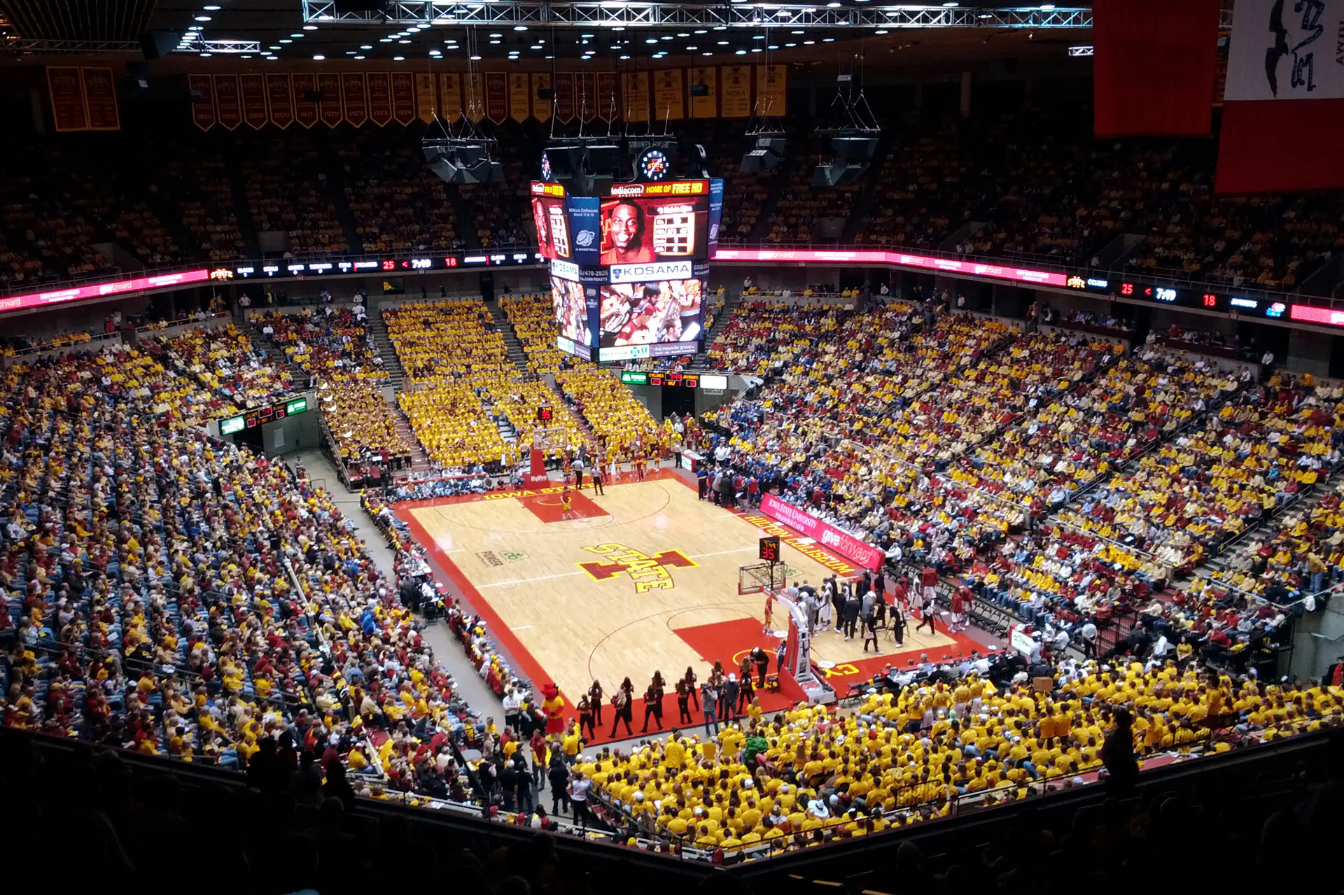 從 Hilton Coliseum 高層看台俯瞰坐滿黃色與紅色上衣球迷的球場全景