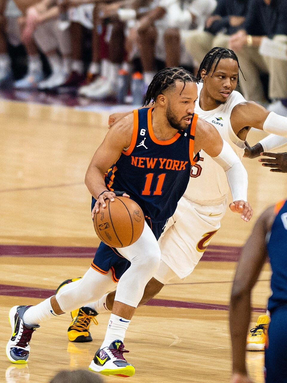 尼克後衛 Jalen Brunson 於比賽中運球切入，身後有騎士隊防守者緊追（攝影：Erik Drost，授權 CC BY 2.5，來源 Wikimedia Commons）