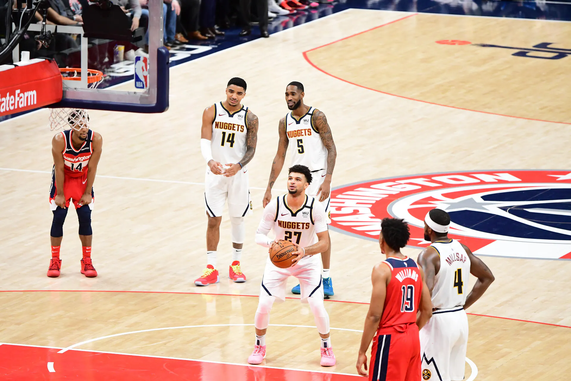 身穿金塊白色 27 號球衣的 Jamal Murray 在罰球線準備出手，隊友站在後方