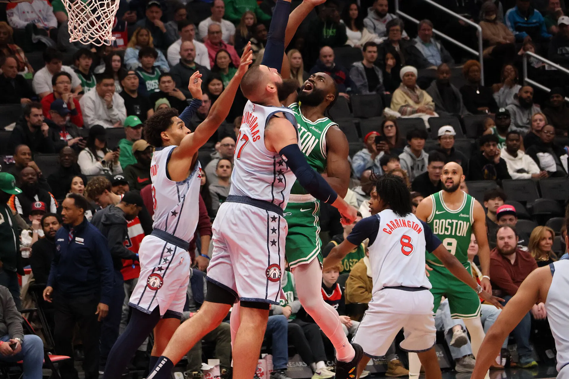 2024 年塞爾提克作客巫師，Jaylen Brown 身穿塞爾提克綠色球衣在籃下出手，巫師 Jonas Valančiūnas 伸手封阻，攝影 Hameltion，授權 CC BY-SA 4.0，來源 Wikimedia Commons