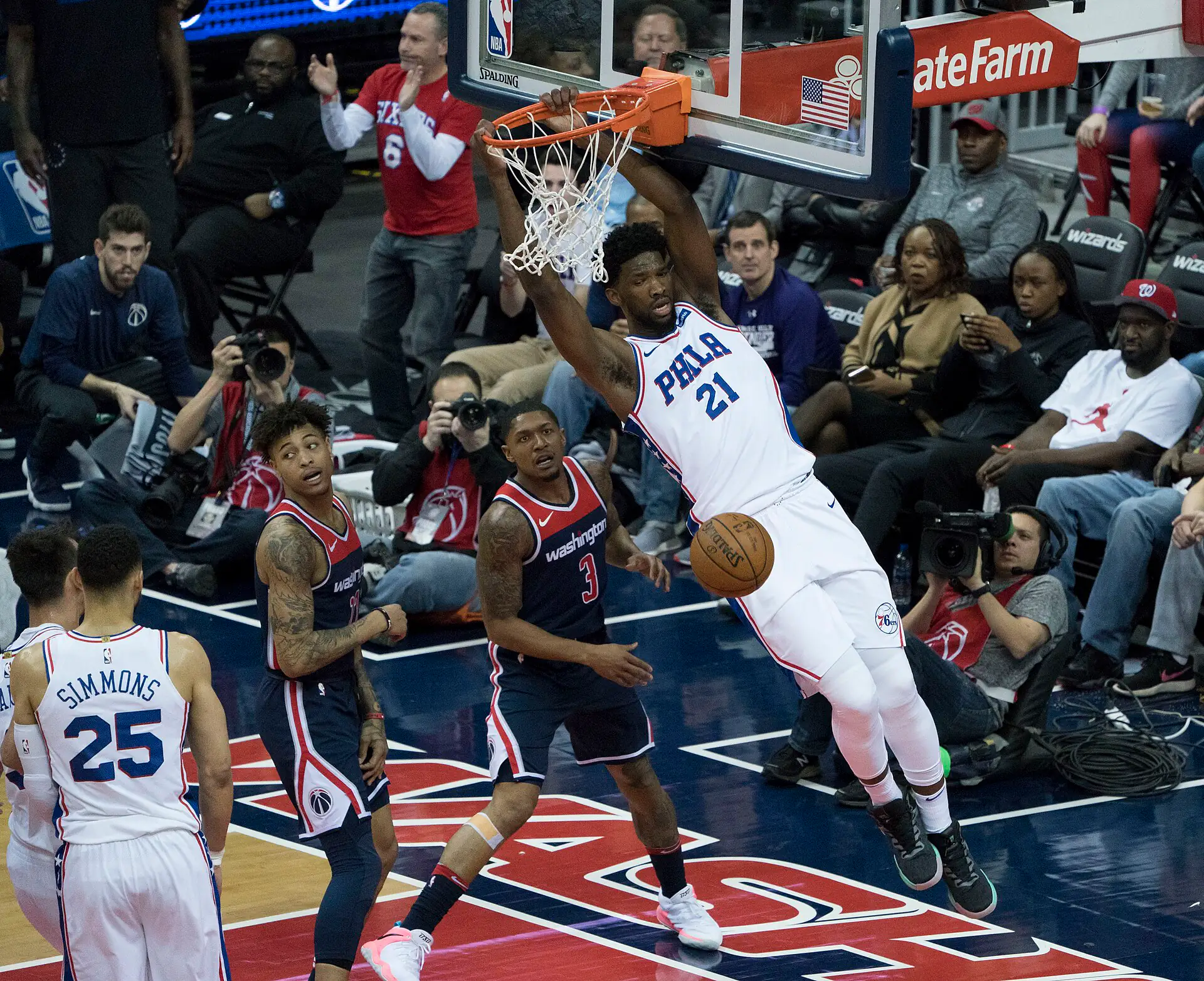 2018 年 76 人作客巫師，Joel Embiid 身穿 76 人白色 21 號球衣灌籃後掛框，攝影 Keith Allison，授權 CC BY-SA 2.0，來源 Wikimedia Commons