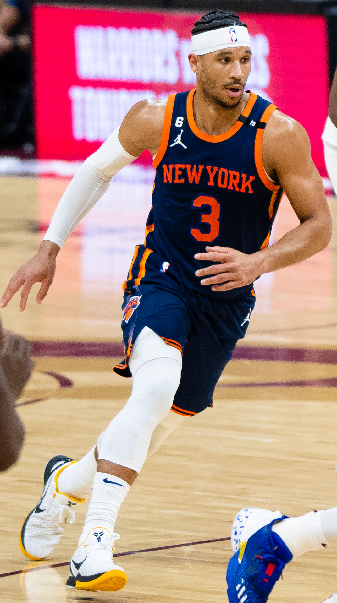 Josh Hart 身穿尼克深藍色客場 3 號球衣、頭戴白色頭帶在場上跑動（攝影 Erik Drost，授權 CC BY 2.0，來源 Wikimedia Commons）