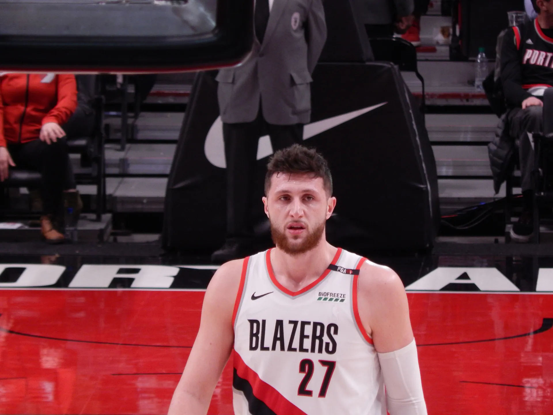 身穿拓荒者白色 27 號球衣的 Jusuf Nurkić 站在球場上