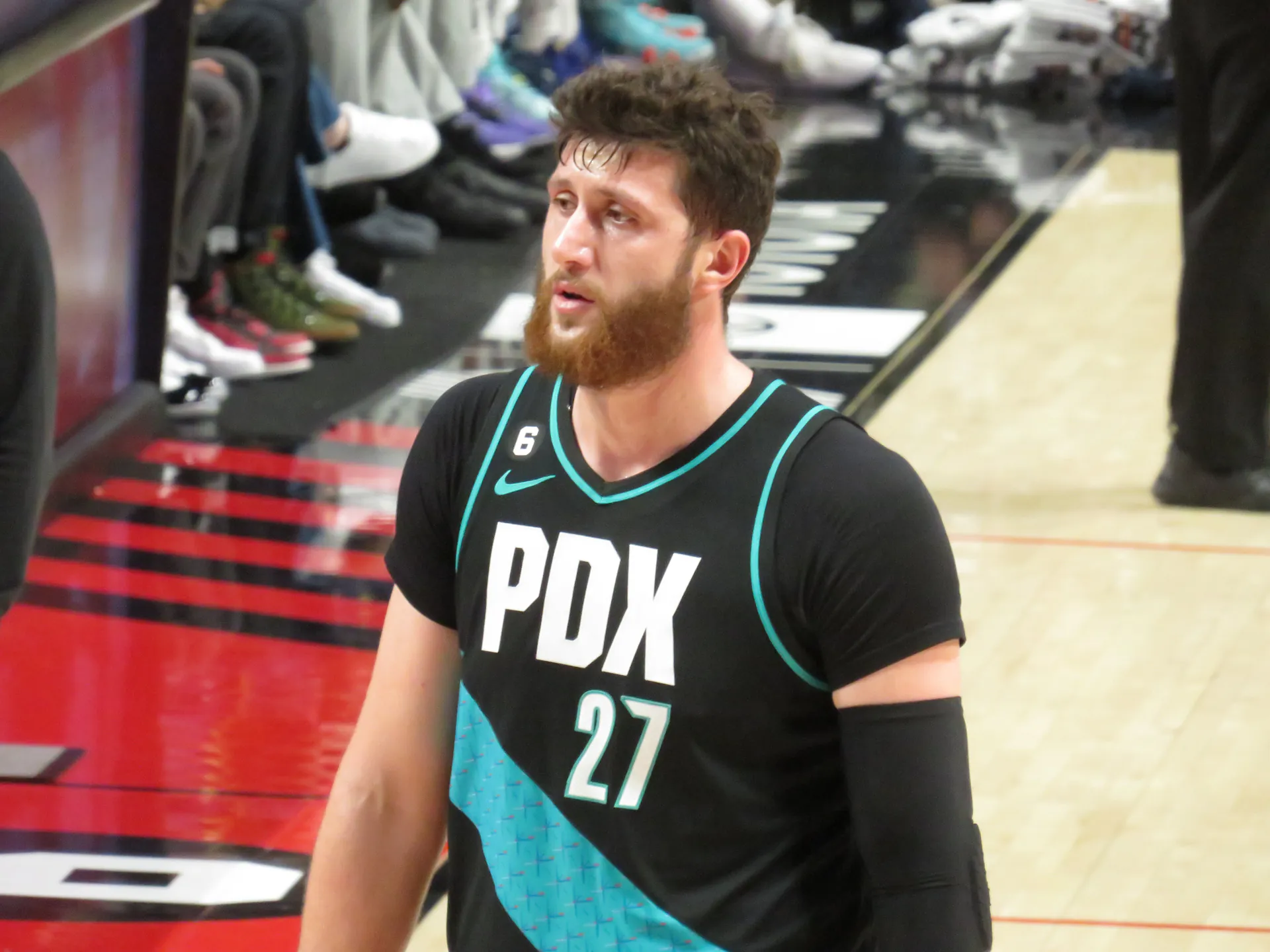 Jusuf Nurkić 身穿波特蘭拓荒者黑色 27 號球衣，於 2022 年 12 月對印第安納溜馬的比賽中走向板凳準備暫停（攝影 Frenchieinportland，授權 CC BY 4.0，來源 Wikimedia Commons）