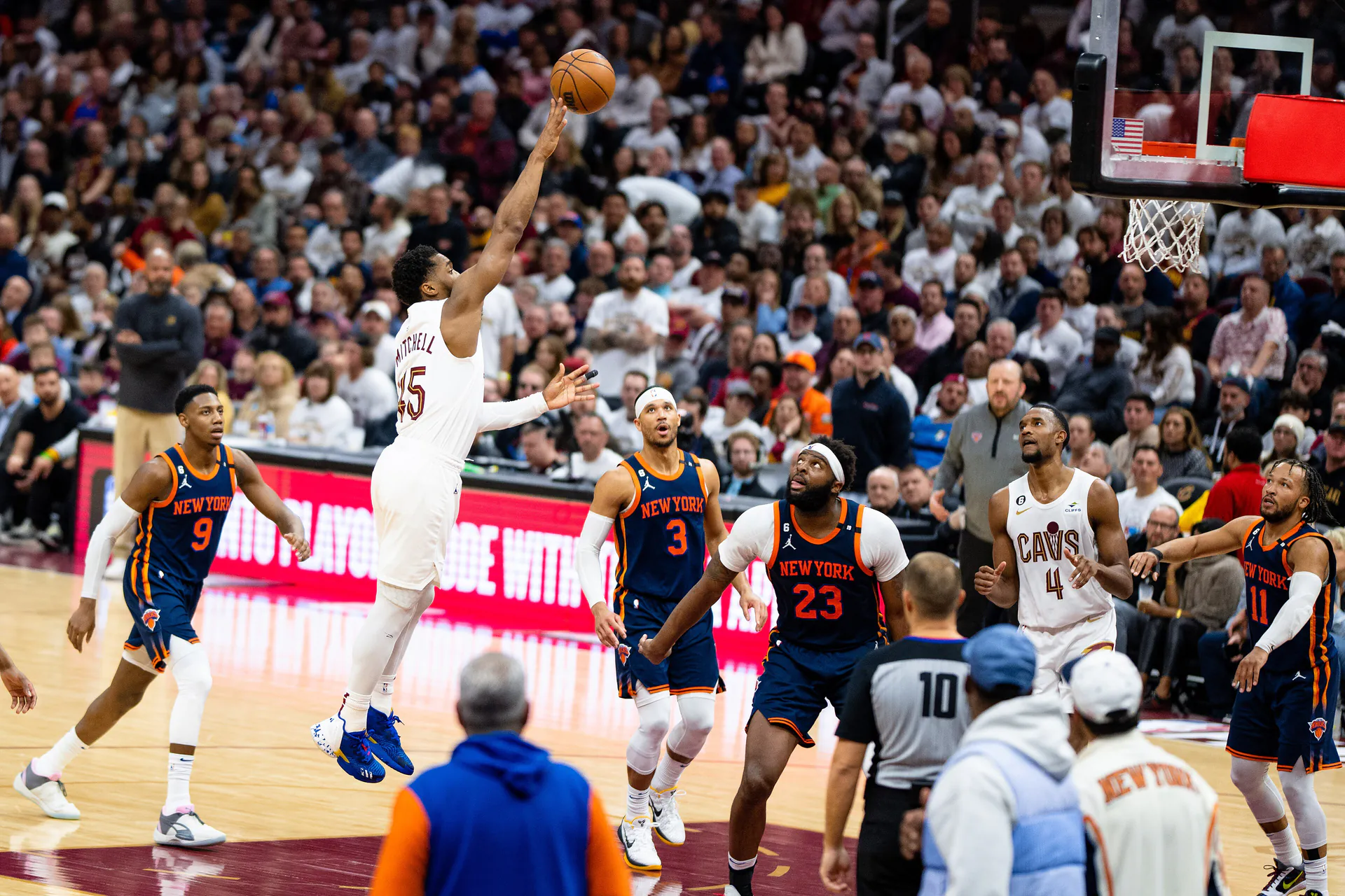 騎士 45 號 Donovan Mitchell 跳起單手出手，尼克 3 號 Josh Hart 與 23 號 Mitchell Robinson 抬頭看球，右側為尼克 11 號 Jalen Brunson（攝影 Erik Drost，授權 CC BY 2.0，來源 Wikimedia Commons）