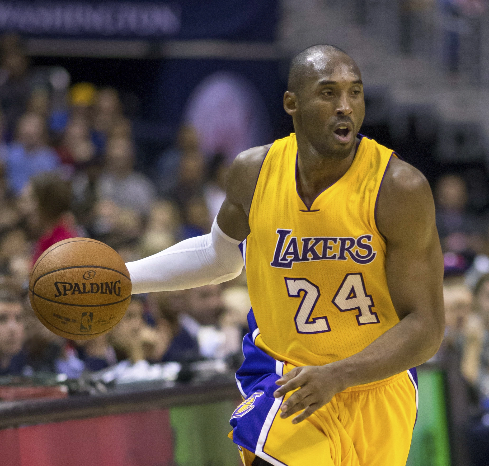 Kobe Bryant 身穿湖人紫色客場球衣在場上持球進攻。攝影：Keith Allison，授權 CC BY-SA 2.0，來源 Wikimedia Commons。