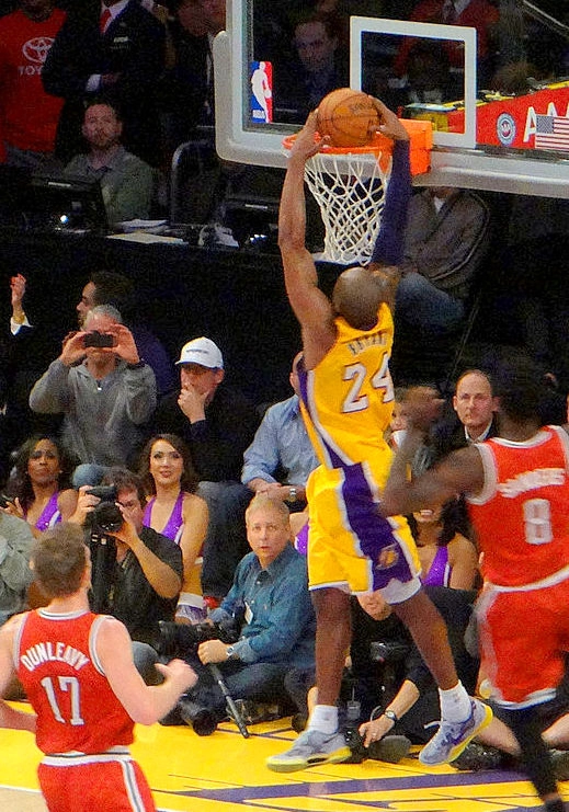 Kobe Bryant 身穿湖人主場白色球衣完成灌籃。攝影：Fido，授權 CC BY 2.0，來源 Wikimedia Commons。