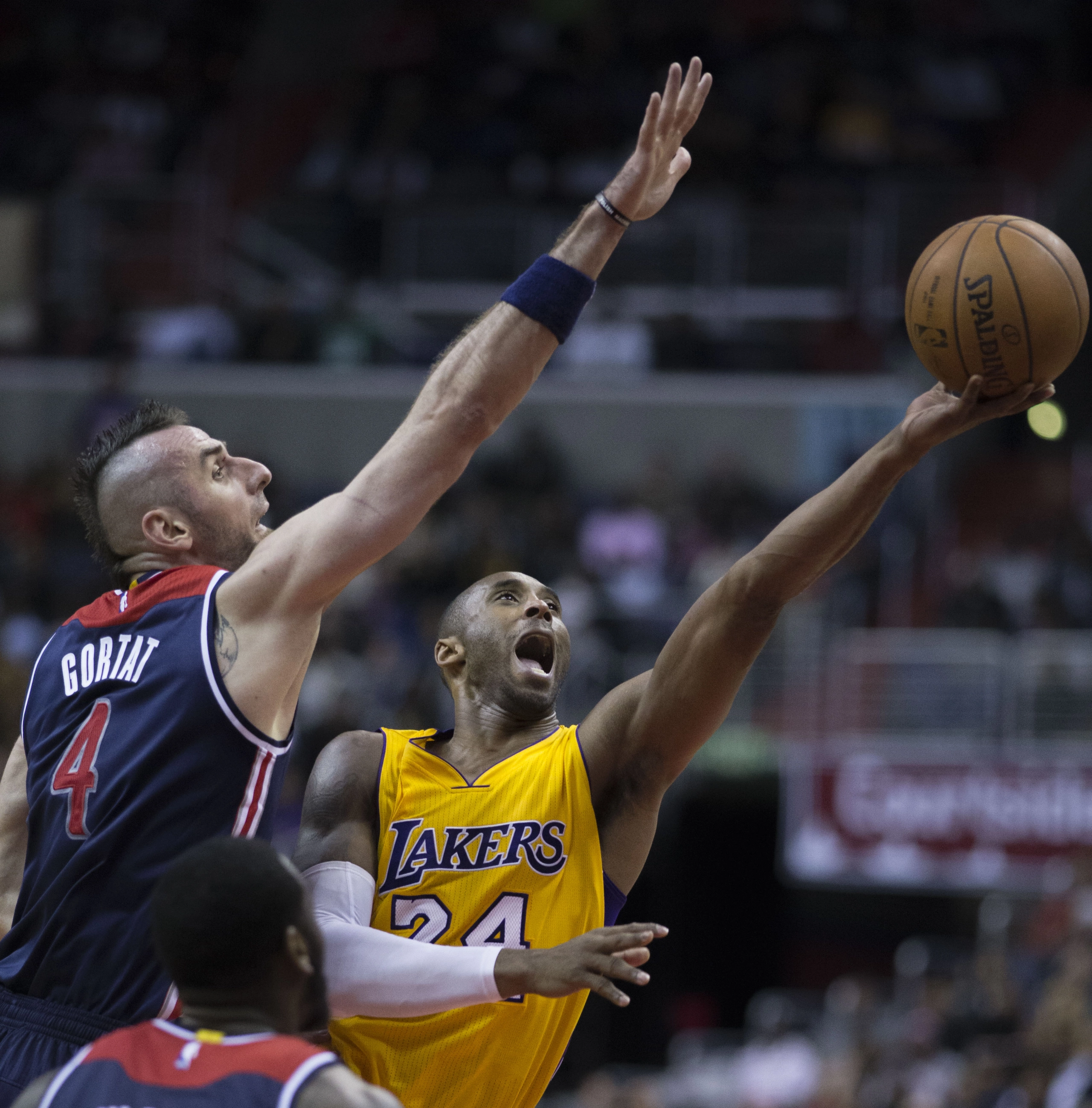 Kobe Bryant 身穿湖人黃色主場球衣越過防守者出手投籃。攝影：Keith Allison，授權 CC BY-SA 2.0，來源 Wikimedia Commons。