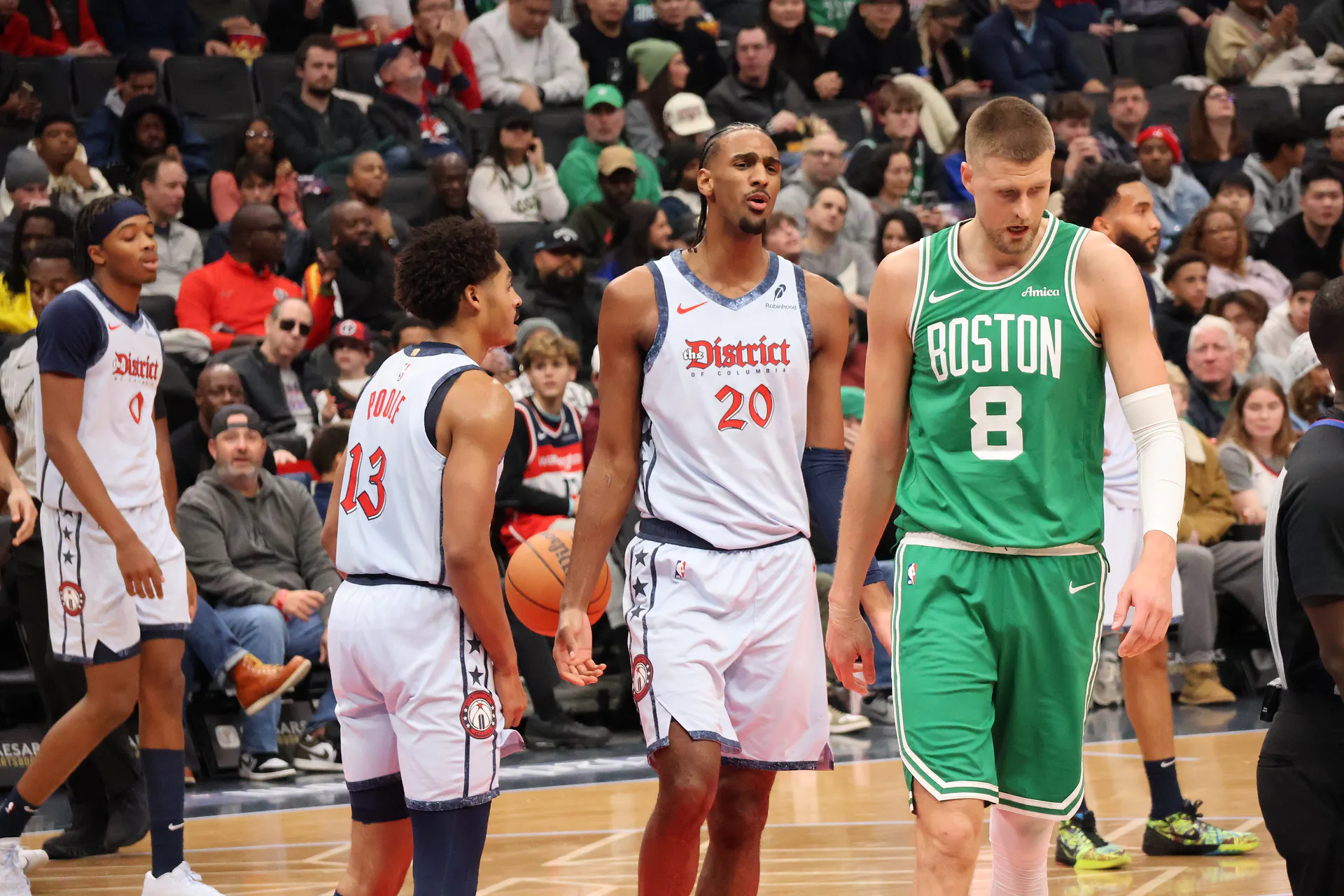 Kristaps Porzingis 身穿塞爾提克綠色 8 號球衣在場上低頭走動，身旁為巫師 20 號與 13 號 Poole 等球員（攝影 Hameltion，授權 CC BY-SA 4.0，來源 Wikimedia Commons）