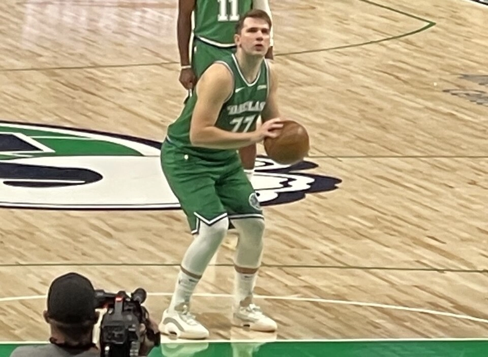 Luka Dončić 效力達拉斯獨行俠時期，身穿綠色 77 號球衣於場上持球（攝影：Jappaji4，授權 CC BY-SA 4.0，來源 Wikimedia Commons）