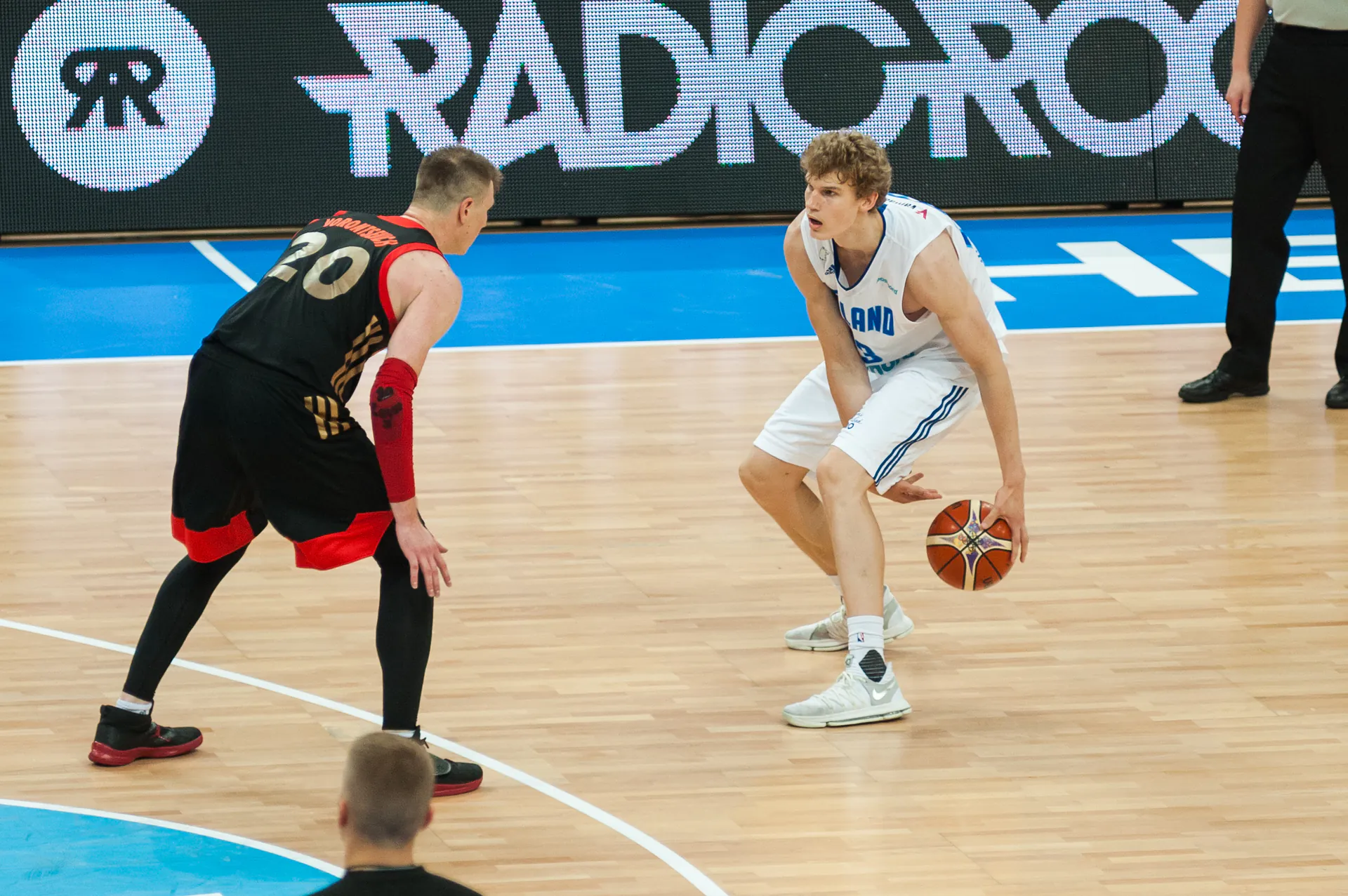 Lauri Markkanen 身穿芬蘭國家隊白色球衣，於 2017 年 8 月 25 日芬蘭對俄羅斯的比賽中持球面對防守者（攝影 Tuomas Vitikainen，授權 CC BY-SA 4.0，來源 Wikimedia Commons）