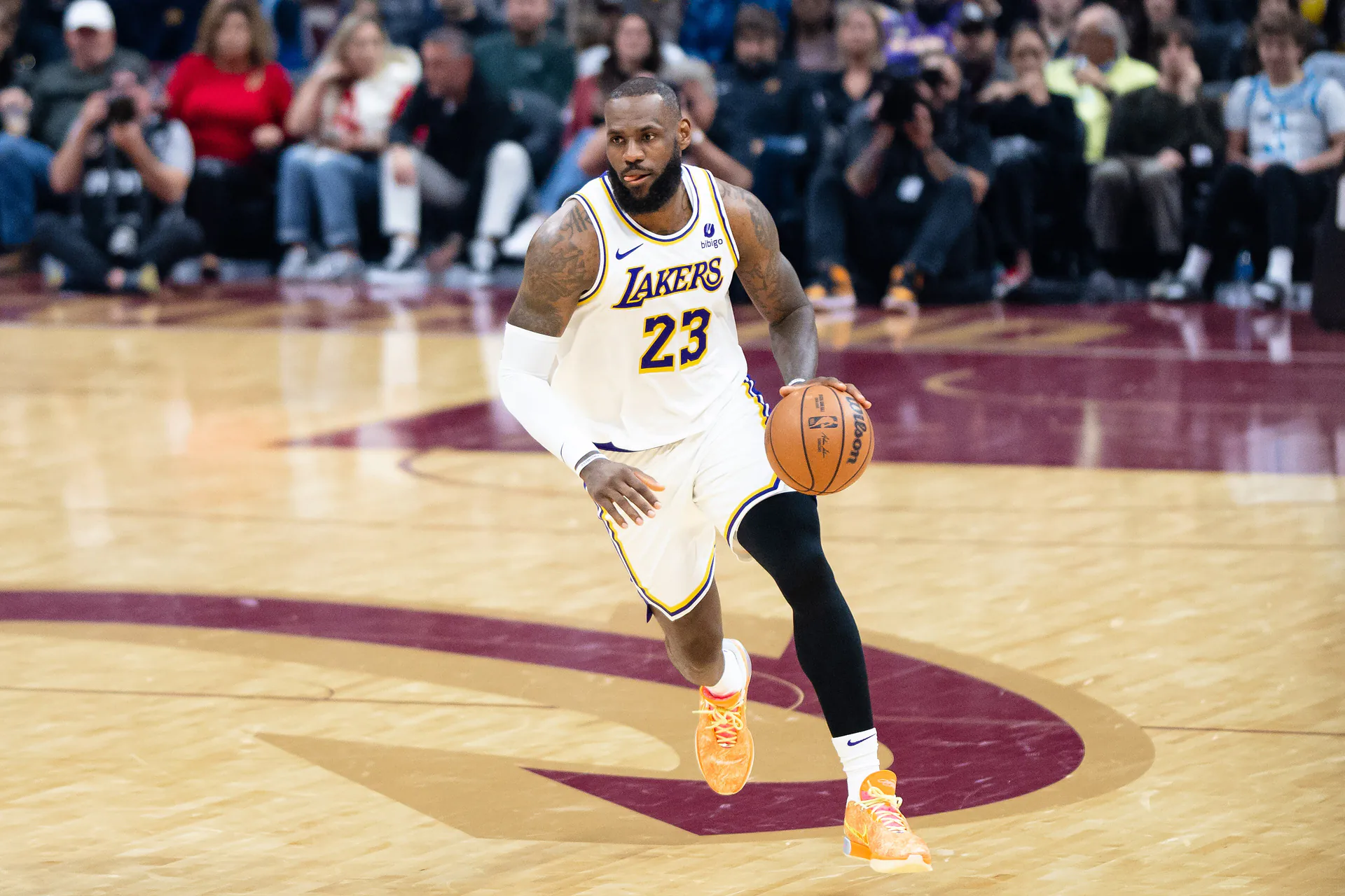 身穿湖人白色 23 號球衣的 LeBron James 在騎士主場運球推進