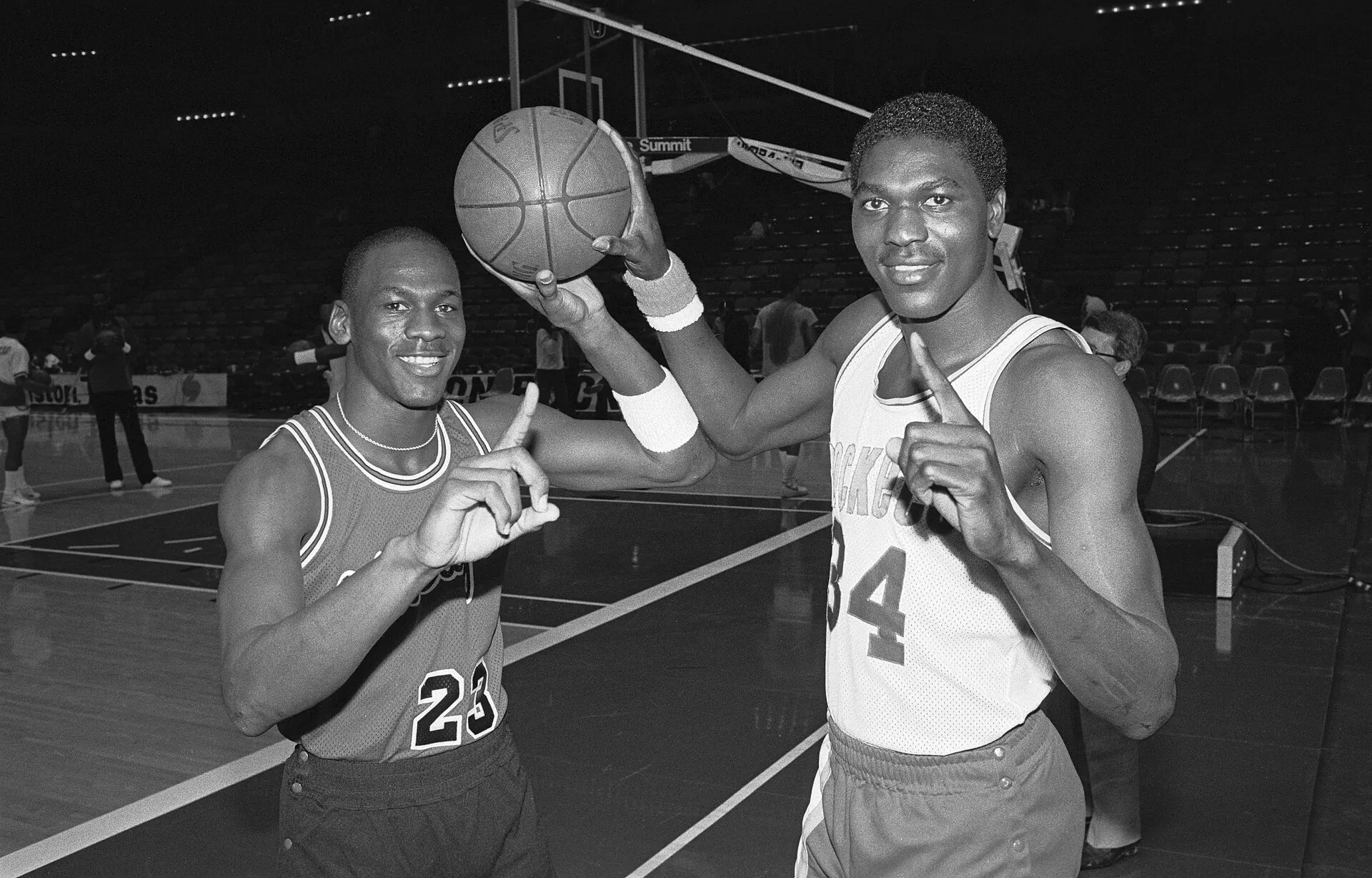 1985 年賽前公牛 Michael Jordan 與火箭 Hakeem Olajuwon 場上合影，UPI 攝，公有領域