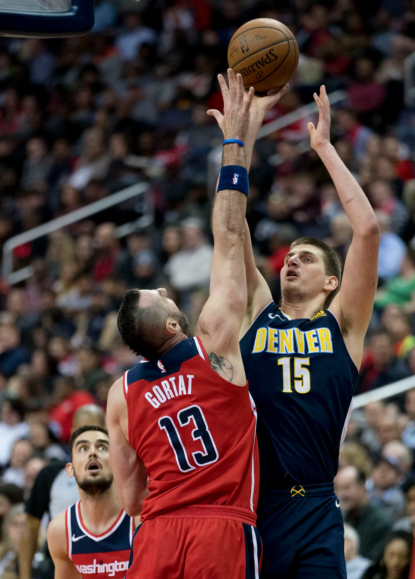 Nikola Jokic 身穿金塊深藍色 15 號球衣，在奇才 Marcin Gortat 防守下跳投出手（攝影 Keith Allison，授權 CC BY-SA 2.0，來源 Wikimedia Commons）
