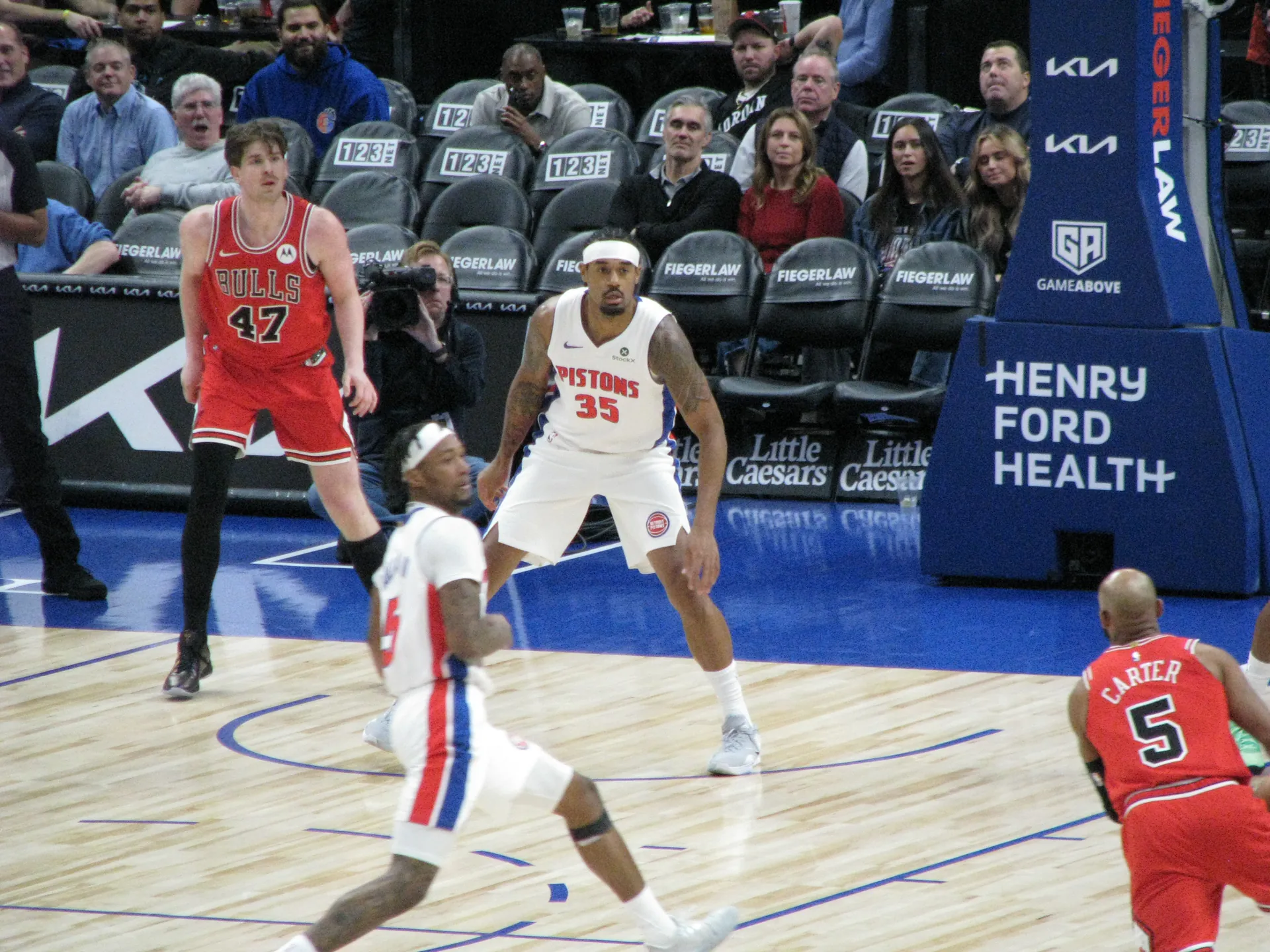 Tolu Smith 身穿活塞白色 35 號球衣在 Little Caesars Arena 防守
