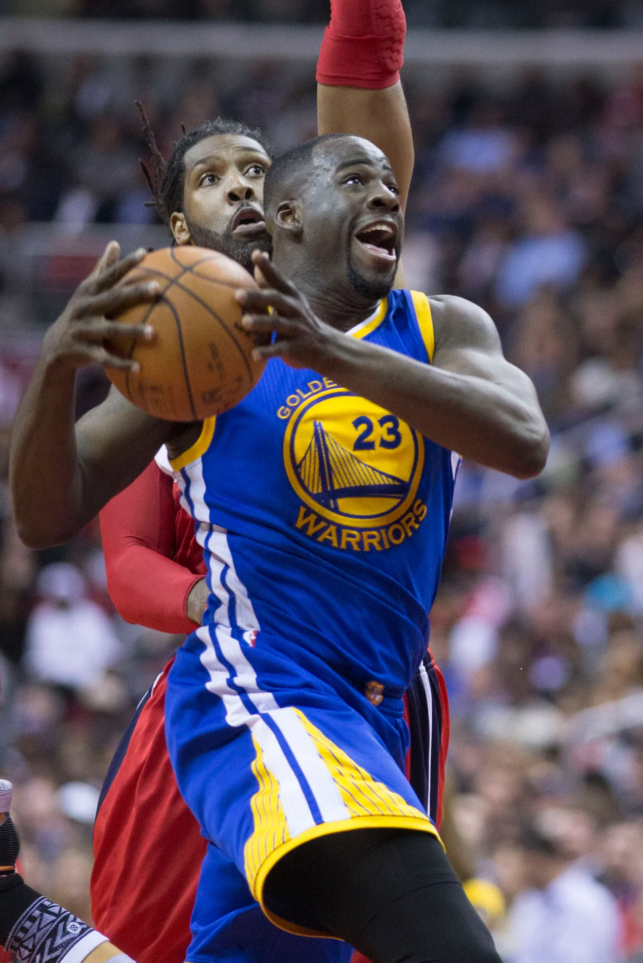 勇士 23 號 Draymond Green 持球切入上籃，身後巫師球員貼身防守（攝影 Keith Allison，授權 CC BY-SA 2.0，來源 Wikimedia Commons）